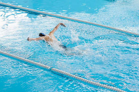 Man swimming in pool, blue water