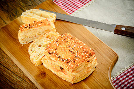 Sliced Bread with Sesame Seeds on a Wooden Board.