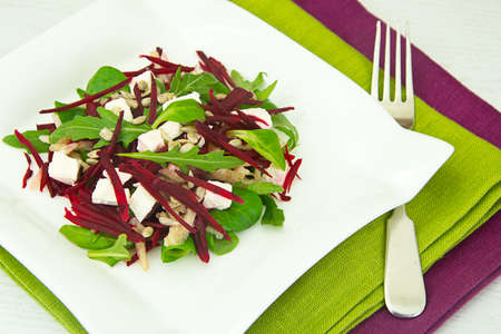 Salad of raw beets, pears, arugula, roots, sunflower seeds and cheese Studio Photo