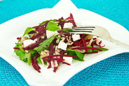 Salad of raw beets, pears, arugula, roots, sunflower seeds and cheese Studio Photo