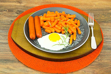 Fried Eggs with Fried Sausages and Carrots. Studio Photoの写真素材