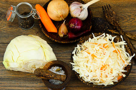 Sauerkraut, Carrot, Salt, Water, Fennel Seeds and Pepper on Wood Background Studio Photoの写真素材