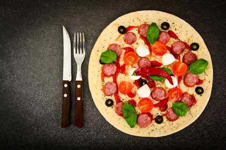 Raw Pepperoni Pizza with Sausage, Cheese, Mozzarella, Olives and Basil Studio Photoの写真素材