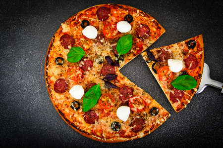 Pepperoni Pizza with Sausage, Cheese, Mozzarella, Olives and Basil Studio Photoの写真素材