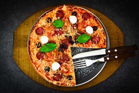 Pepperoni Pizza with Sausage, Cheese, Mozzarella, Olives and Basil Studio Photoの写真素材