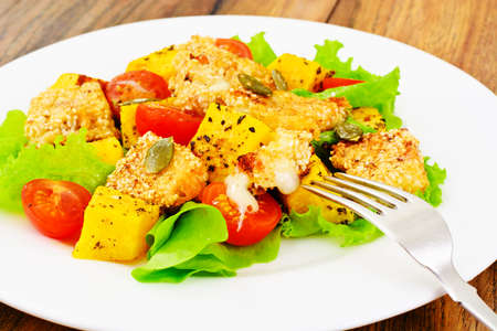 Pumpkin Salad, Suluguni Fried in Sesame, Pumpkin Seeds, Cherry Tomatoes and Lettuce Leaves Studio Photoの写真素材