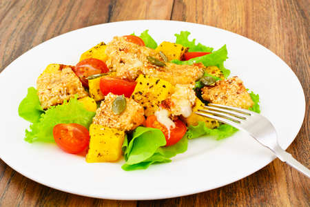 Pumpkin Salad, Suluguni Fried in Sesame, Pumpkin Seeds, Cherry Tomatoes and Lettuce Leaves Studio Photoの写真素材