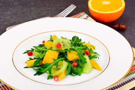 Fresh mango, arugula, kiwi, orange and pomegranate on White Plate. Studio Photoの写真素材