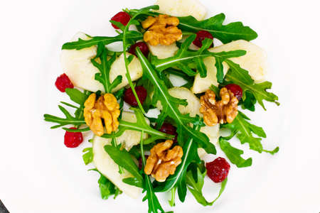 Dietary Delicious Salad on White Plate of Arugula, Par, Walnut and Dried Cherry. Studio Photo