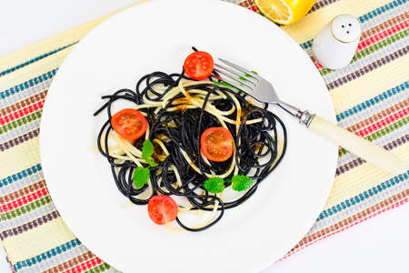 Black Spaghetti with Cuttlefish Ink, Tomato and Basil. Mediterranean and Asian Cuisine. Studio Photoの写真素材