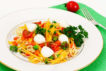Warm Salad of Noodles, Pumpkin, Carrots, Peas with Cherry Tomatoes and Mozzarella Studio Photoの写真素材