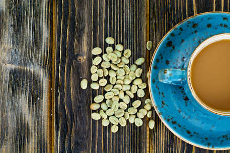 Coffee with Milk, Cappuccino in a Blue Retro Cup with Green Coffee Beans Studio Photo