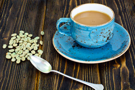 Coffee with Milk, Cappuccino in a Blue Retro Cup with Green Coffee Beans Studio Photoの写真素材
