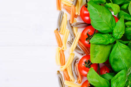 Green Fresh Basil with Tomato on White Woody Board Background Studio Photoの写真素材