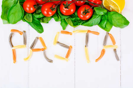 Green Fresh Basil with Tomato on White Woody Board Background Studio Photoの写真素材