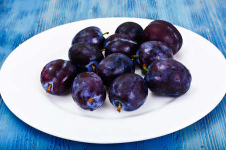 Juicy Ripe Plums on Woody Background Studio Photoの写真素材