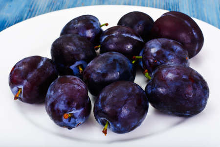 Juicy Ripe Plums on Woody Background Studio Photoの写真素材
