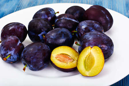Juicy Ripe Plums on Woody Background Studio Photoの写真素材