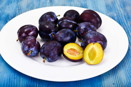 Juicy Ripe Plums on Woody Background Studio Photoの写真素材