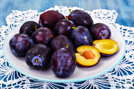 Juicy Ripe Plums on Woody Background Studio Photoの写真素材