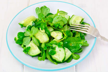 Salad with Cucumber, Purslane and Green Peas on Dark Disks Studio Photoの写真素材