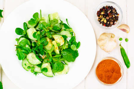 Salad with Cucumber, Purslane and Green Peas on Dark Disks Studio Photoの写真素材