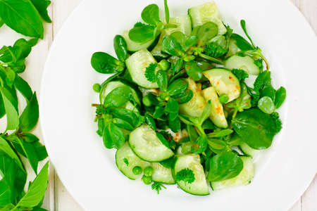 Salad with Cucumber, Purslane and Green Peas on Dark Disks Studio Photoの写真素材