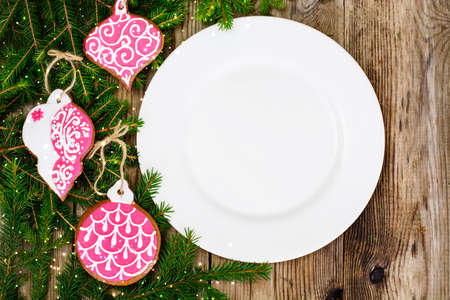 Abstract Christmas and New Year Background with Old Vintage Wooden Boards, Fir Branches, White Empty Plate and Glossy Lights Studio Photoの写真素材
