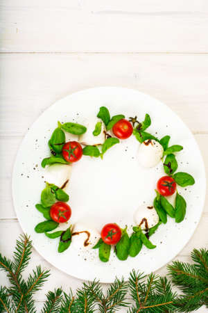 Christmas wreath caprese salad festive appetizer on a white plate. Studio Photoの写真素材