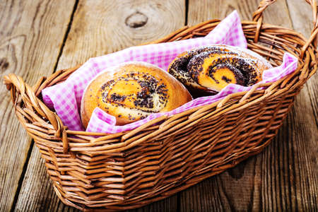 Buns with poppy seeds in a bread basket. Studio photoの写真素材