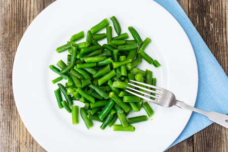 Salad of green beans on white plate. Studio Photo