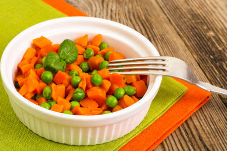 Carrots and green peas on a couple of Dietの写真素材