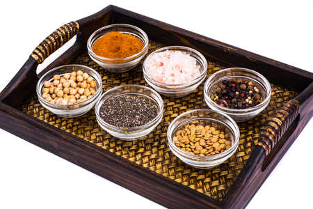 Set of spices and seeds of legumes in glass molds on trayの写真素材