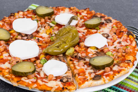 Home pizza with mozzarella and pickled gherkinsの写真素材