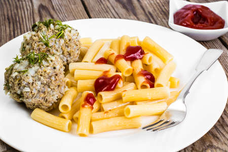 Pasta with meatballs and ketchup for lunchの写真素材