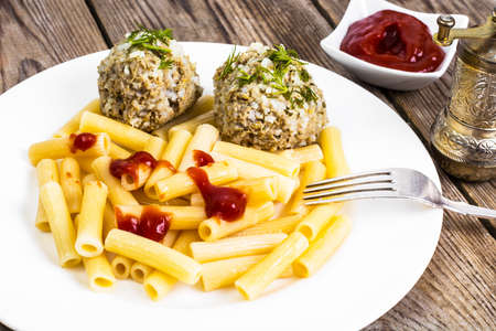 Pasta with meatballs and ketchup for lunch
