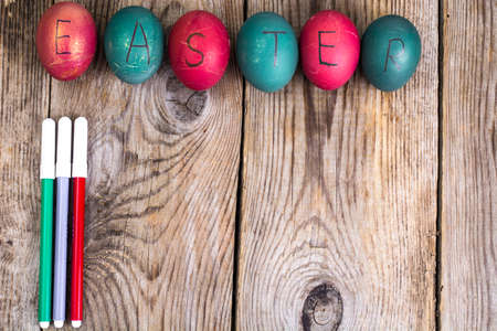 Easter eggs painted on white plate on wooden backgroundの写真素材