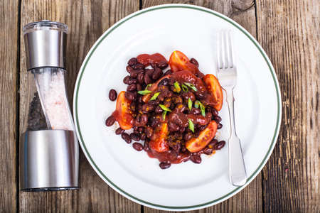 Red beans, tomatoes, ketchup, onion and spices on the white platの写真素材