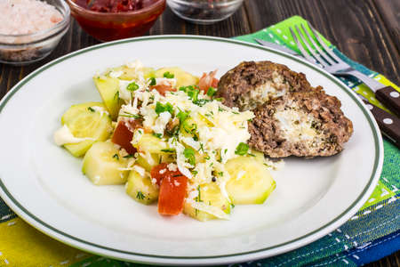 Meatballs stuffed with cheese with vegetable saladの写真素材