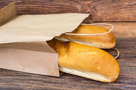 Fresh warm baguette in paper bagの写真素材