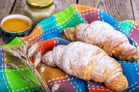 Croissants with powdered sugar on background of old boardsの写真素材