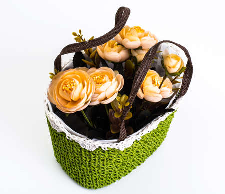 Green knitted decorative basket of flowersの写真素材
