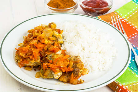 Greek baked fish with carrot, onion and riceの写真素材