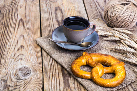 Pretzels with salt and black coffee on wooden backgroundの写真素材