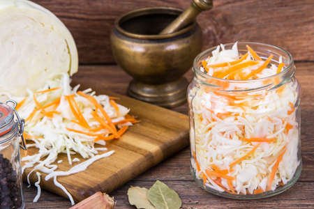 Sauerkraut with carrots in glass jarの写真素材