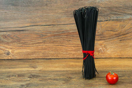 Spaghetti with squid ink on wooden backgroundの写真素材