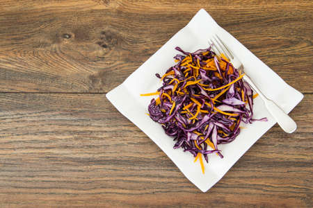 Salad of red cabbage and carrots on white plateの写真素材