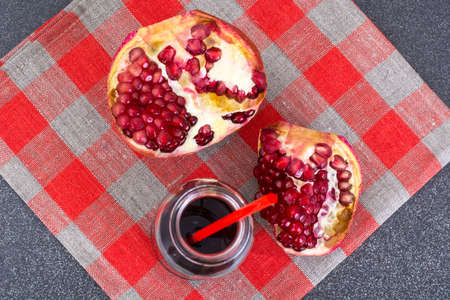 Broken in half pomegranate and juice in bottleの写真素材
