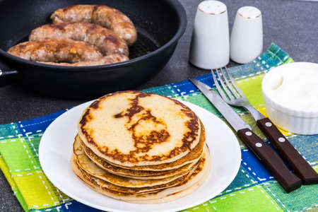 Hot pancakes with homemade sausage in frying pan. Studio Photoの写真素材