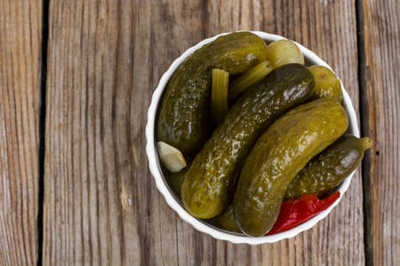 Marinated cornichons in white bowl. Studio Photoの写真素材